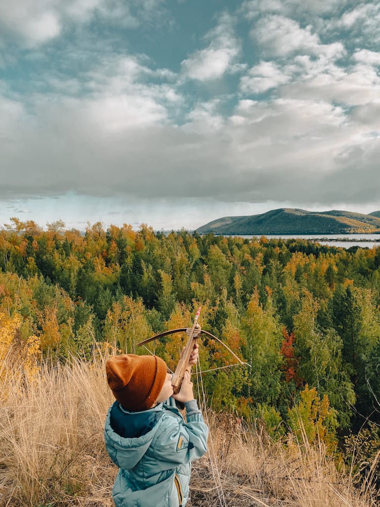 Boy with Wooden Bow in Field